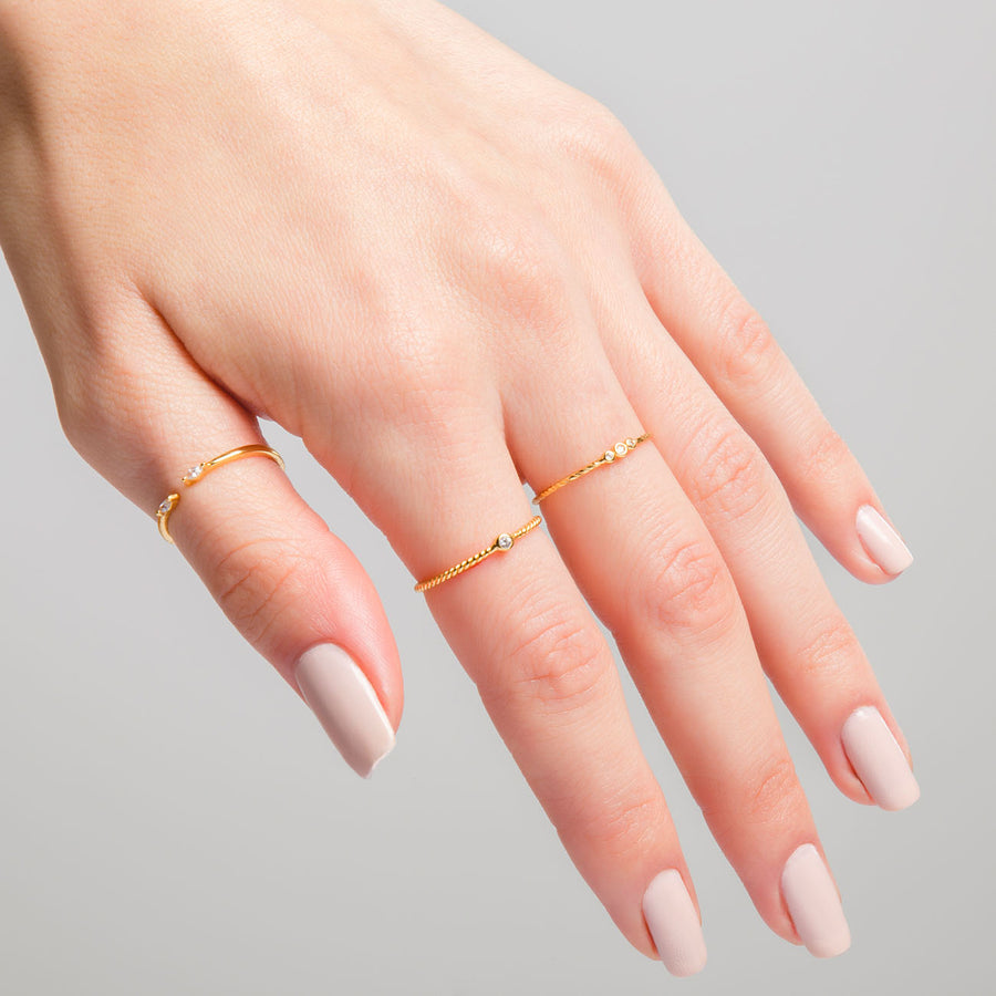 Mano con anillo JImena Gold y otros anillos de oro con circonitas blancas
