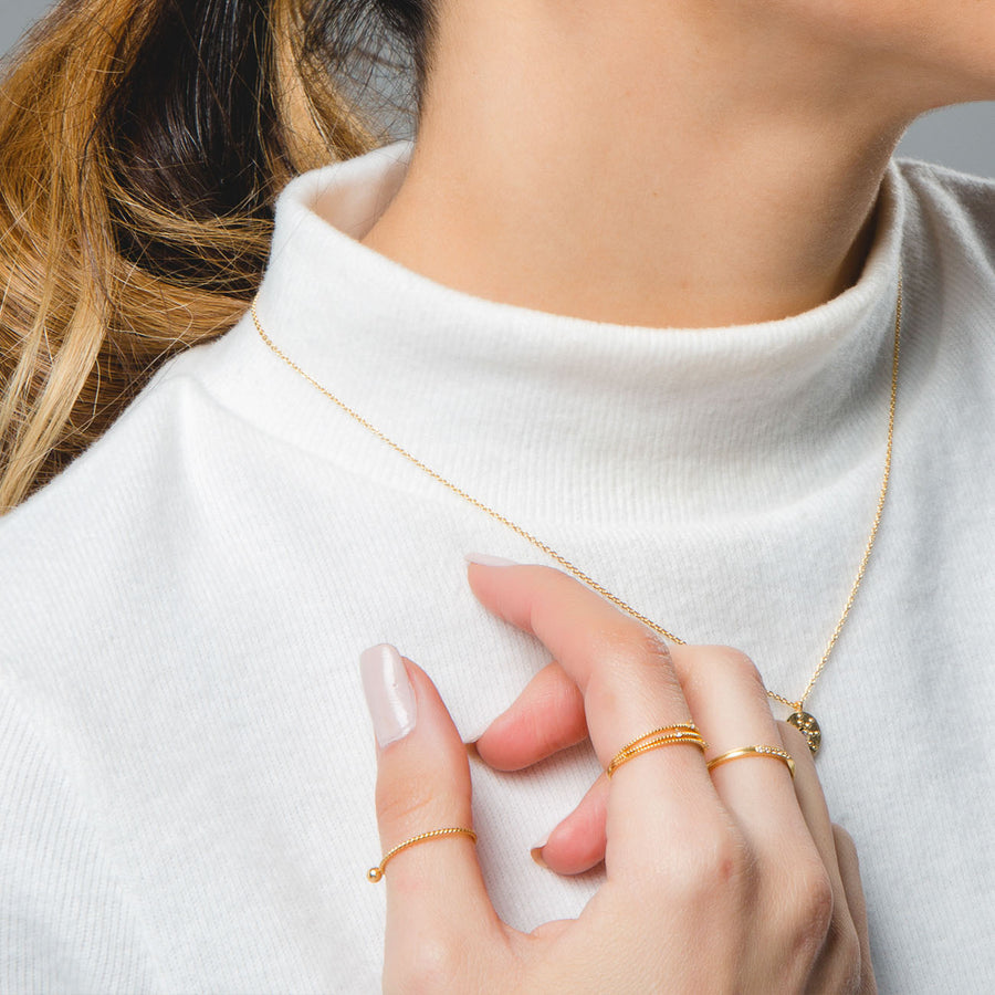 Mujer con collar y anillos de oro de Adamina