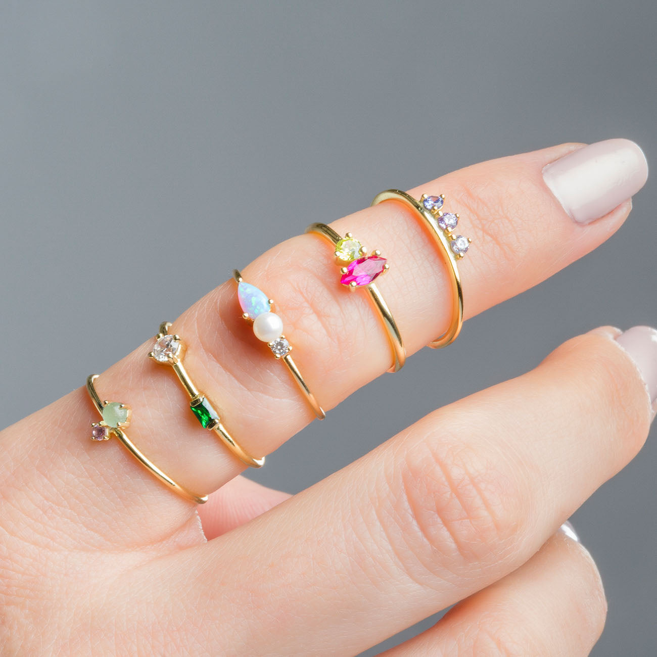 Dedo en primer plano con varios anillos de oro con circnonitas