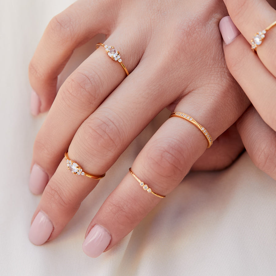 Mano con anillo Tiara Gold y varios anillos con circonitas blancas